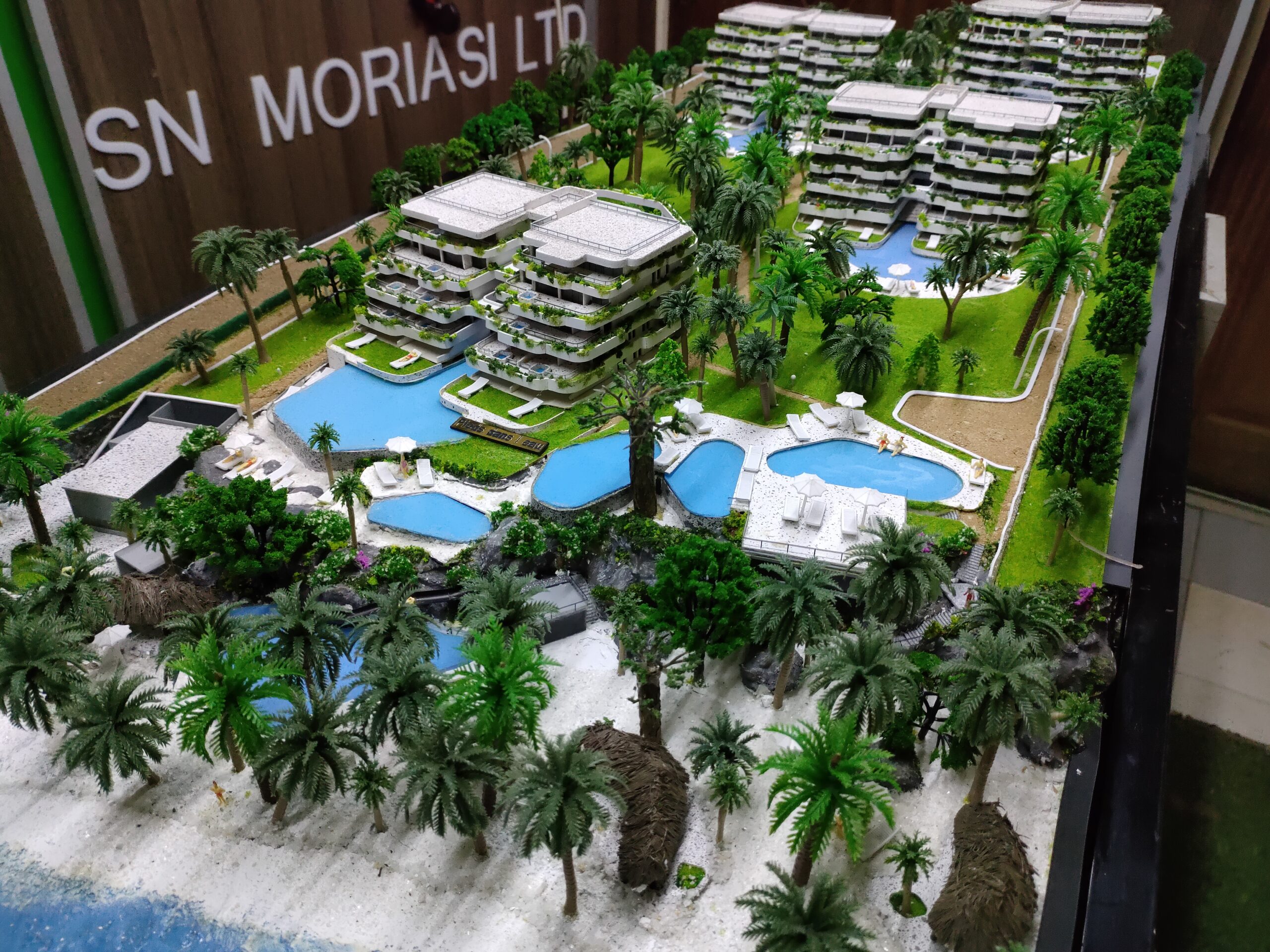 Detailed architectural scale model under examination in a professional workspace